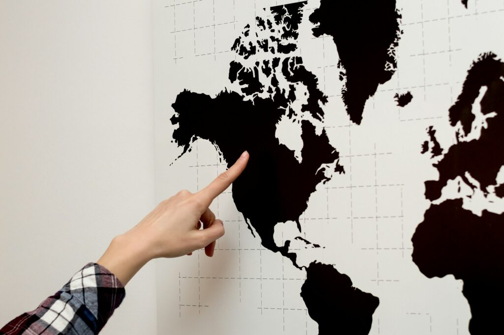 Woman is pointing on world map.